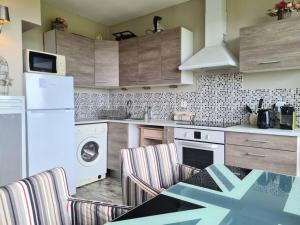 a kitchen with a washer and dryer and a table and chairs at Vue mer, 2 Pièces, balcon, parking privé. in Bénerville-sur-Mer