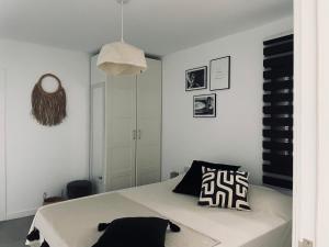 1 dormitorio con 1 cama con almohada blanca y negra en Ocean shore apartment 2, en Puerto de Santiago