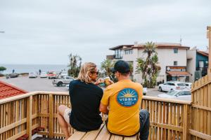 a man and a woman sitting on a wooden deck at 7 Pepper Street by African Perfection in Jeffreys Bay