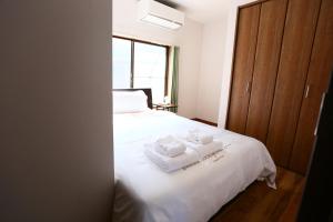 1 dormitorio con 1 cama con 2 toallas en Kita 2 Storey Homestay, en Tokio