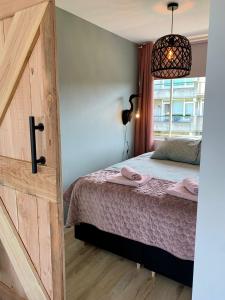 um quarto com uma cama e uma janela em Amsterdam Beach Apartment 76 em Zandvoort