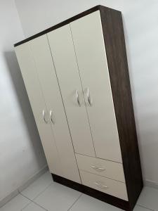 a wardrobe with white cabinets in a room at Reis Veloso in Parnaíba