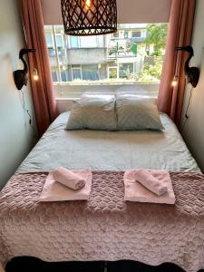 uma cama com duas toalhas num quarto com uma janela em Amsterdam Beach Apartment 76 em Zandvoort