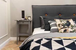 1 dormitorio con 1 cama con cabecero negro y mesa en Nobel Apartment - BEST LOCATION!, en Cracovia