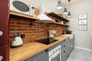 cocina con microondas y pared de ladrillo en Nobel Apartment - BEST LOCATION!, en Cracovia