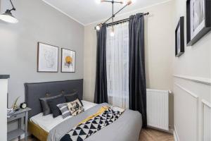 un dormitorio con una cama y una ventana en Nobel Apartment - BEST LOCATION!, en Cracovia