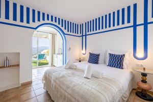 - une chambre avec un grand lit aux rayures bleues et blanches dans l'établissement Sumptuous B&B Villa Provençale - 2BR4p, à Grimaud