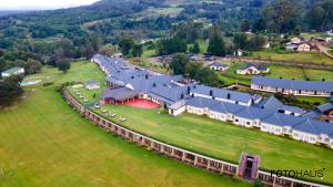 an aerial view of a large house with a green field at Troutbeck Resort in Nyanga