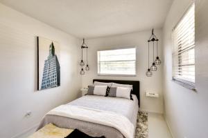 a bedroom with a bed with white sheets and a window at Bright Florida Home with Patio and Grill, Near Beaches in New Smyrna Beach