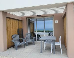 patio con mesa y sillas en el balcón en La Vigie Vacances en Les Sables-dʼOlonne