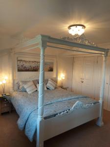 Un dormitorio con una cama grande con dosel. en Hot Tub Hideaway, en Hemyock