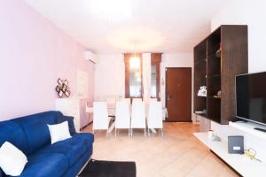 a living room with a blue couch and a dining room at Casa Elia in Reggio Emilia