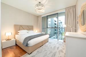 een slaapkamer met een bed en een groot raam bij FAM Living City Walk - Opposite City Walk Mall - 2A in Dubai