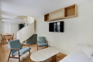 a living room with two chairs and a staircase at Pick A Flat's Properties in Invalides - Rue de Grenelle in Paris
