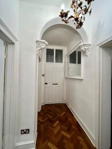 a hallway with a white door and a chandelier at Islington - Greater London Apartment in London