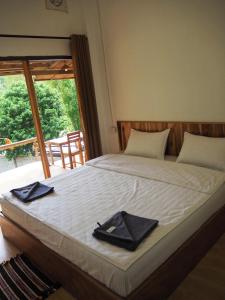 a bed with two black napkins on top of it at Meexok river view in Nongkhiaw