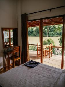 a bedroom with a bed and a view of a deck at Meexok river view in Nongkhiaw