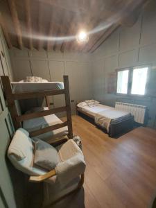 Zimmer mit 2 Etagenbetten und einem Stuhl in der Unterkunft Turisme Rural Ca l'Axai casa 3 in Pi