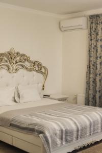 Un dormitorio con una cama blanca con cabecero dorado. en Готель Хутір, en Malyye Khutora