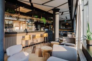 un restaurante con un bar con mesas y sillas blancas en Hotel Aquarion Family & Friends en Zakopane