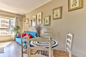 comedor con mesa y sofá azul en Green Point Apartment, en Ciudad del Cabo