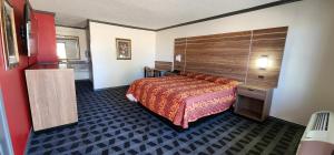 a hotel room with a bed and a wooden headboard at Victorian Inn Midland in Midland +12 photos