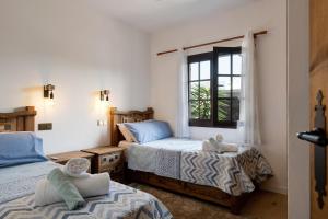 Un dormitorio con dos camas y una ventana. en Villa Maylands, en Playa Blanca 27 fotos más