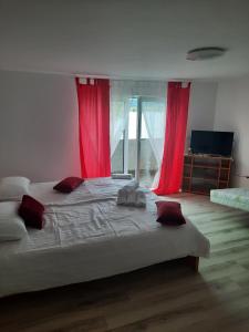 1 dormitorio con 1 cama grande y cortinas rojas en Apartma Ob jezeru, 
