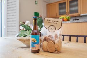a bottle of beer sitting on a table with a bag of bread at Quinta Pedra dos Bicos By Albufeira Rental in Albufeira
