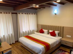 Un dormitorio con una cama grande con almohadas rojas. en Studio Apartment, en Katmandú