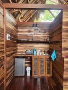 a kitchen with wooden walls and a sink in a cabin at Cielva Tayrona Cabaña Amanecer in Los Naranjos