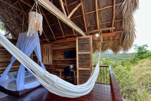 um quarto com uma rede de descanso numa cabana em Cielva Tayrona Cabaña Amanecer em Los Naranjos