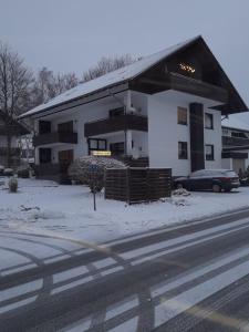 a white building with a car parked in front of it at Haus Annemiek in Winterberg