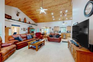 sala de estar con muebles de cuero y TV de pantalla plana en Osprey Cabin, en Pinetop-Lakeside