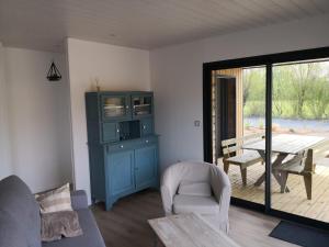 a living room with a tv and a chair and a table at Gîtes des Embruns in Agon-Coutainville