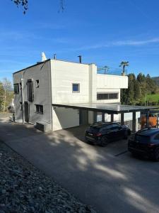 een huis met twee auto's ervoor geparkeerd bij Villa Ossiacher Tauern in Feldkirchen in Kärnten