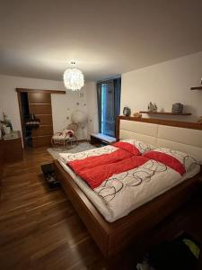 een slaapkamer met een groot bed en een kroonluchter bij Villa Ossiacher Tauern in Feldkirchen in Kärnten