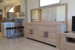 a kitchen with a counter with stools and a tv at Studio climatisé avec terrasse, fibre et Wi FI . in Saint-Marcel-lès-Valence
