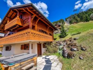 a wooden house with a balcony on a hill at Le Chalet des Ours in Châtel