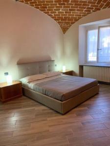 ein Schlafzimmer mit einem großen Bett und zwei Nachttischen in der Unterkunft Al Canun di Casale Monferrato in Casale Monferrato