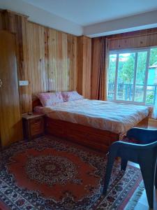 a bedroom with a bed with a window and a rug at Tigerhill Homestay in Darjeeling