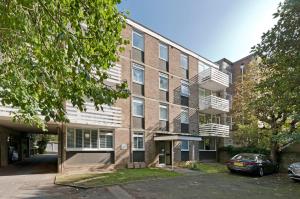 an apartment building with a basketball court in front of it at Botanical bliss near Kew Gardens by UnderTheDoormat in London