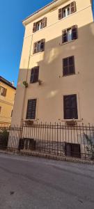 un bâtiment avec des fenêtres et une clôture à côté d'une rue dans l'établissement Saint Peter s roof, à Rome