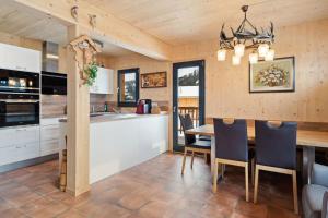 cocina y comedor con mesa y sillas en Chalet in Hohentauern - Chalet Ana, en Hohentauern