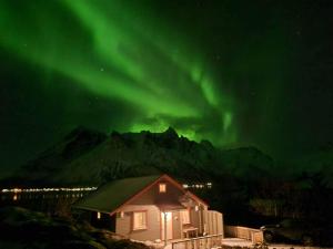 una imagen de una casa con la aurora en el cielo en Sildpollnes Lodge en Laupstad