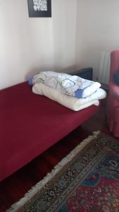a bed with a blanket on top of a red mattress at Peñazcal casita feliz in Bilbao