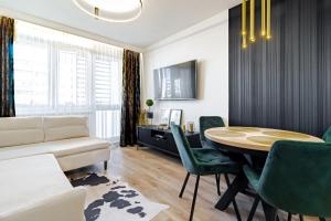 a living room with a table and green chairs at Apartament Gold in Biała Podlaska