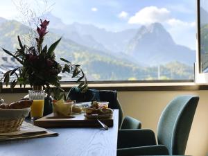 a table with a plate of food and a view of a mountain at BergChalet in Garmisch-Partenkirchen