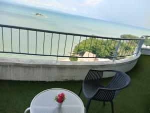 a table and two chairs on a balcony with the ocean at Beachfront Sea View Penang in Tanjung Bungah
