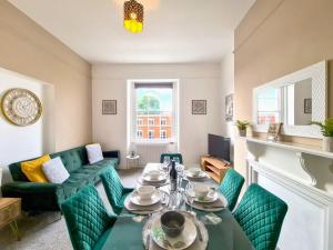 een woonkamer met een tafel en groene stoelen bij Margaret's Quattro in Cheltenham